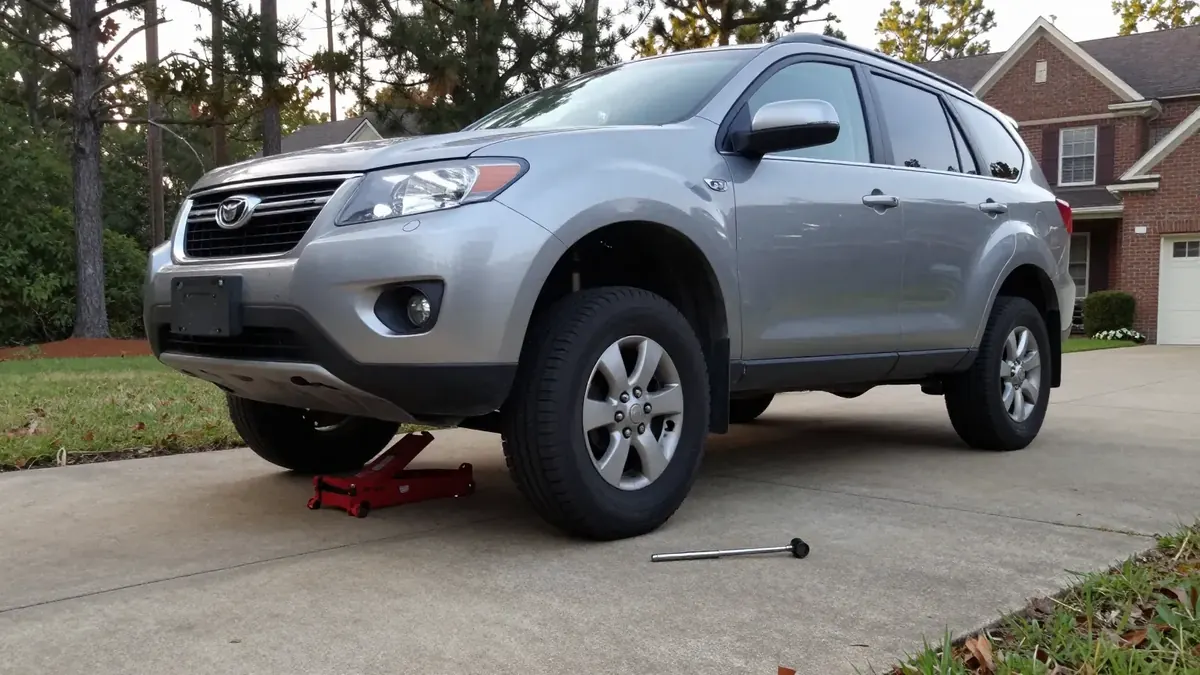 SUV on jack stands with a front wheel off in a Columbia SC driveway