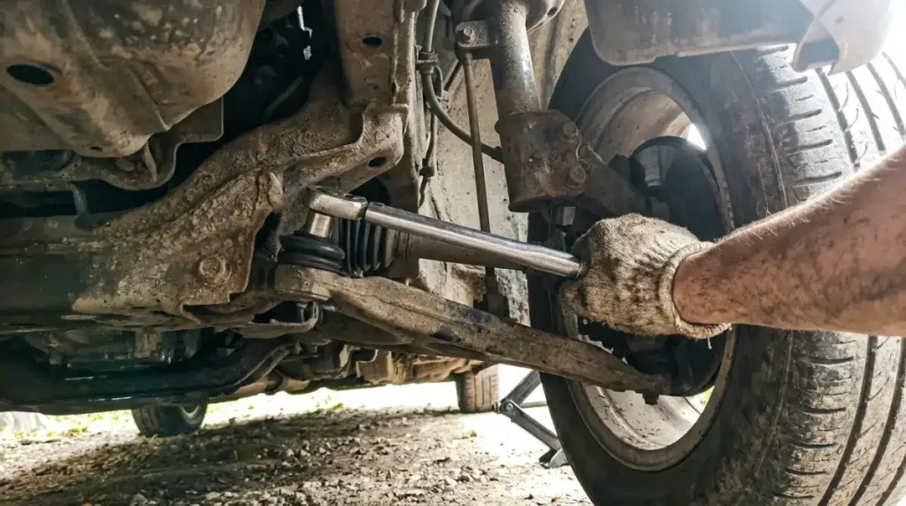 Mechanic replacing a suspension control arm under a car in Columbia SC